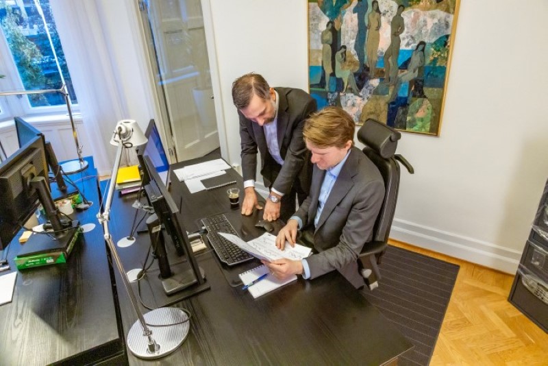 two people at a huge desk reading a document